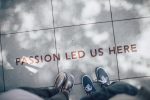 Two people standing on a footpath above a sign 'Passion led us here'